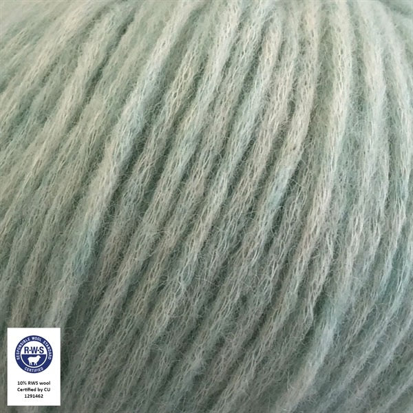 Close-up van een bol Snefnug-garen in een zachte verfijnde subtiel mint kleur. Dit lichte blowyarn heeft een kern van katoen met ingeblazen alpaca- en merinovezels, wat zorgt voor een luchtige, pluizige structuur. Onderaan zijn de RAS- en RWS-certificeringslogo's zichtbaar.