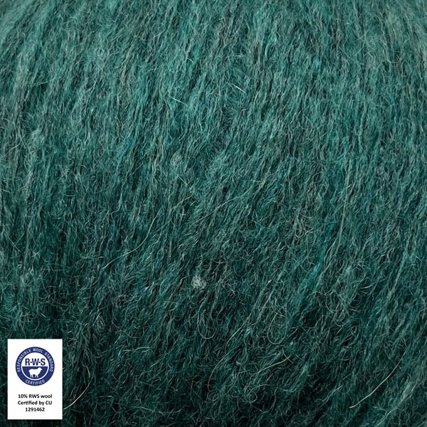 Close-up van een bol Snefnug-garen in een jadegroene kleur. Dit lichte blowyarn heeft een kern van katoen met ingeblazen alpaca- en merinovezels, wat zorgt voor een luchtige, pluizige structuur. Onderaan zijn de RAS- en RWS-certificeringslogo's zichtbaar.