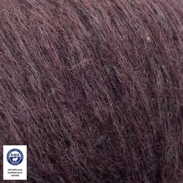 Close-up van een bol Snefnug-garen in een aubergine kleur. Dit lichte blowyarn heeft een kern van katoen met ingeblazen alpaca- en merinovezels, wat zorgt voor een luchtige, pluizige structuur. Onderaan zijn de RAS- en RWS-certificeringslogo's zichtbaar.