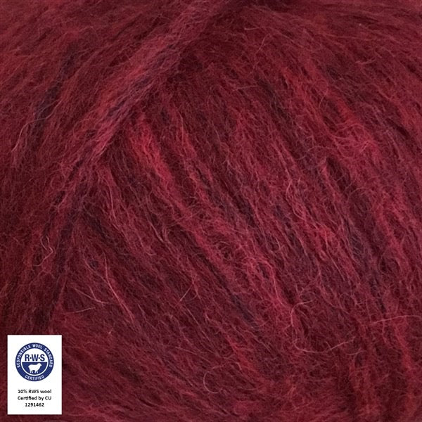 Close-up van een bol Snefnug-garen in een warme roest rode kleur. Dit lichte blowyarn heeft een kern van katoen met ingeblazen alpaca- en merinovezels, wat zorgt voor een luchtige, pluizige structuur. Onderaan zijn de RAS- en RWS-certificeringslogo's zichtbaar.