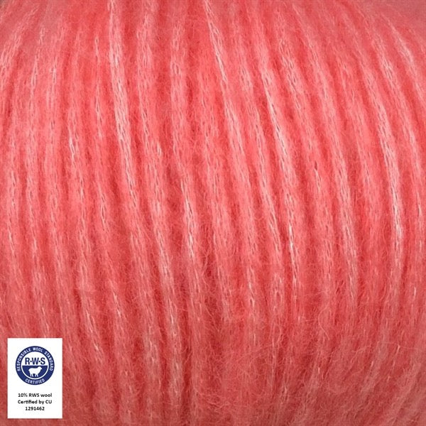 Close-up van een bol Snefnug-garen in een warme helder roze kleur kleur. Dit lichte blowyarn heeft een kern van katoen met ingeblazen alpaca- en merinovezels, wat zorgt voor een luchtige, pluizige structuur. Onderaan zijn de RAS- en RWS-certificeringslogo's zichtbaar.