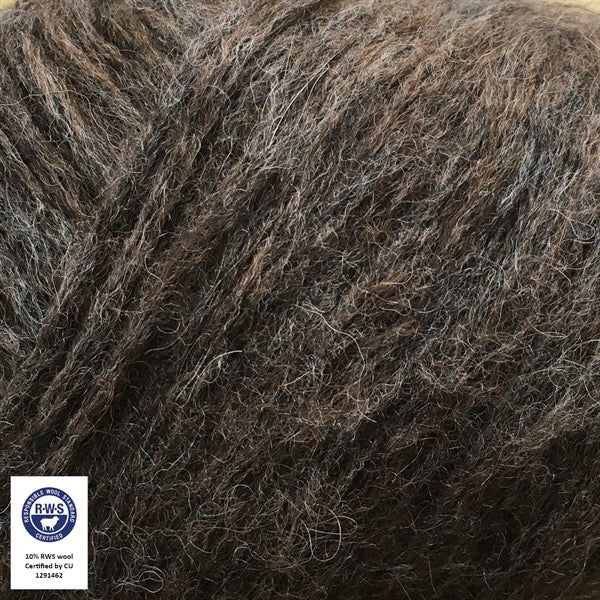 Close-up van een bol Snefnug-garen in een donkerbruine, kleur. Dit lichte blowyarn heeft een kern van katoen met ingeblazen alpaca- en merinovezels, wat zorgt voor een luchtige, pluizige structuur. Onderaan zijn de RAS- en RWS-certificeringslogo's zichtbaar