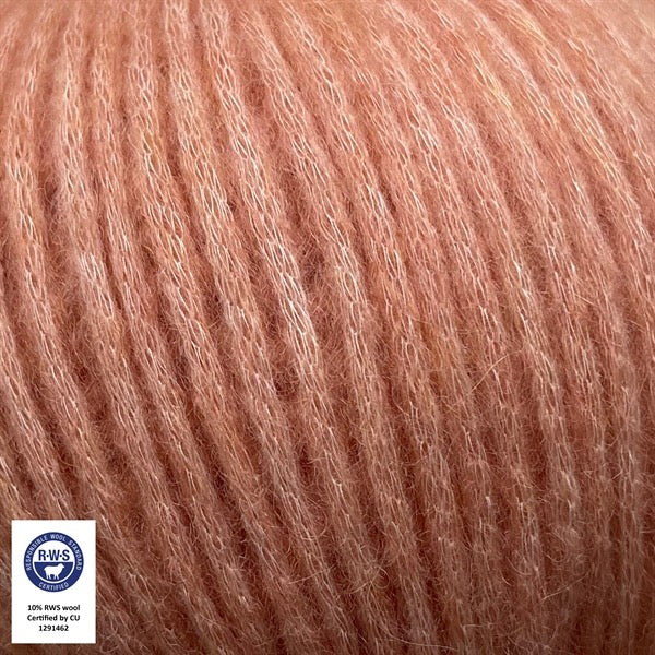 Close-up van een bol Snefnug-garen in een diepe perzik kleur. Dit lichte blowyarn heeft een kern van katoen met ingeblazen alpaca- en merinovezels, wat zorgt voor een luchtige, pluizige structuur. Onderaan zijn de RAS- en RWS-certificeringslogo's zichtbaar.