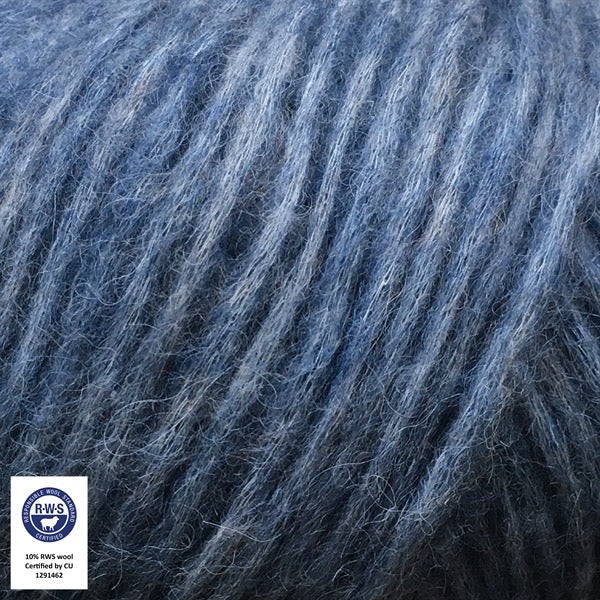 Close-up van een bol Snefnug-garen in een Jeansblauwe kleur. Dit lichte blowyarn heeft een kern van katoen met ingeblazen alpaca- en merinovezels, wat zorgt voor een luchtige, pluizige structuur. Onderaan zijn de RAS- en RWS-certificeringslogo's zichtbaar.