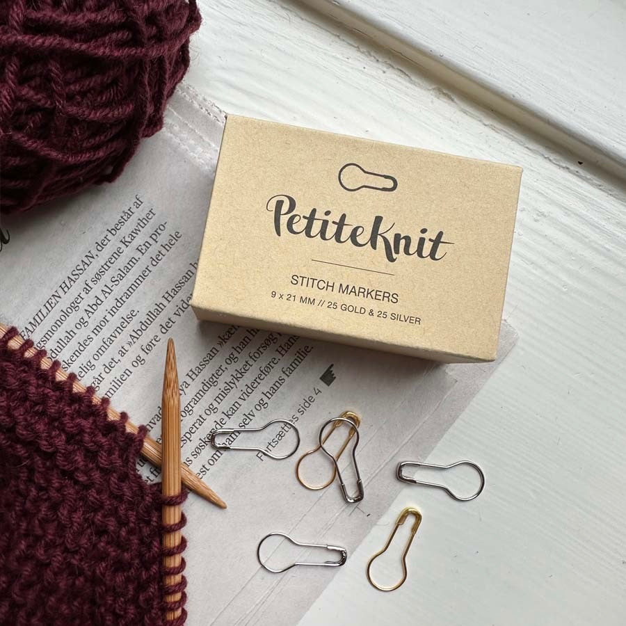 Kartonnen doosje met magneet sluiting gevuld met opening stitch markers van PetiteKnit
