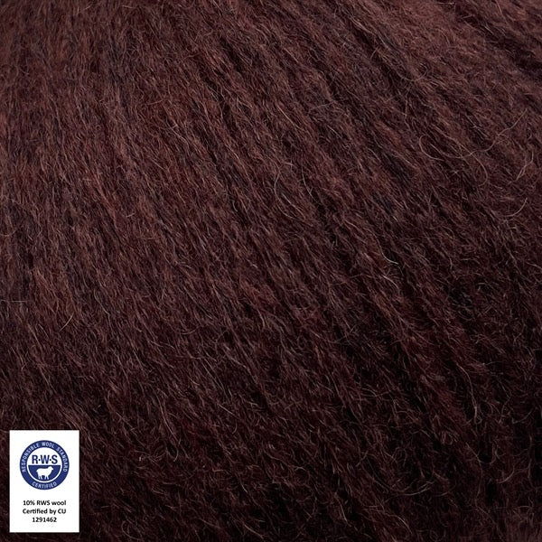 Close-up van een bol Snefnug-garen in een kastanjebruine  kleur. Dit lichte blowyarn heeft een kern van katoen met ingeblazen alpaca- en merinovezels, wat zorgt voor een luchtige, pluizige structuur. Onderaan zijn de RAS- en RWS-certificeringslogo's zichtbaar.