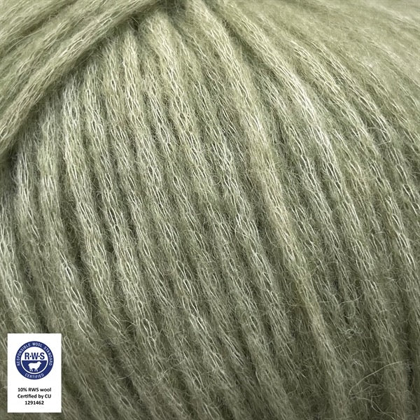Close-up van een bol Snefnug-garen in een zachte groene kleur. Dit lichte blowyarn heeft een kern van katoen met ingeblazen alpaca- en merinovezels, wat zorgt voor een luchtige, pluizige structuur. Onderaan zijn de RAS- en RWS-certificeringslogo's zichtbaar.