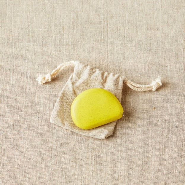 Tape measure van Cocoknits in Mosterd groene kleur op een canvas zakje