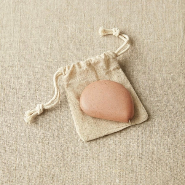 Tape measure van Cocoknits in terracotta kleur op een canvas zakje