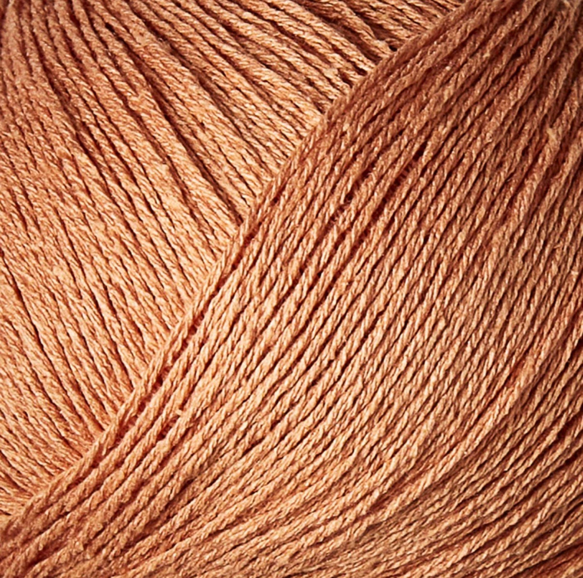 Close-up van zacht oranje bourettezijde met een matte uitstraling en een licht onregelmatige, natuurlijke structuur