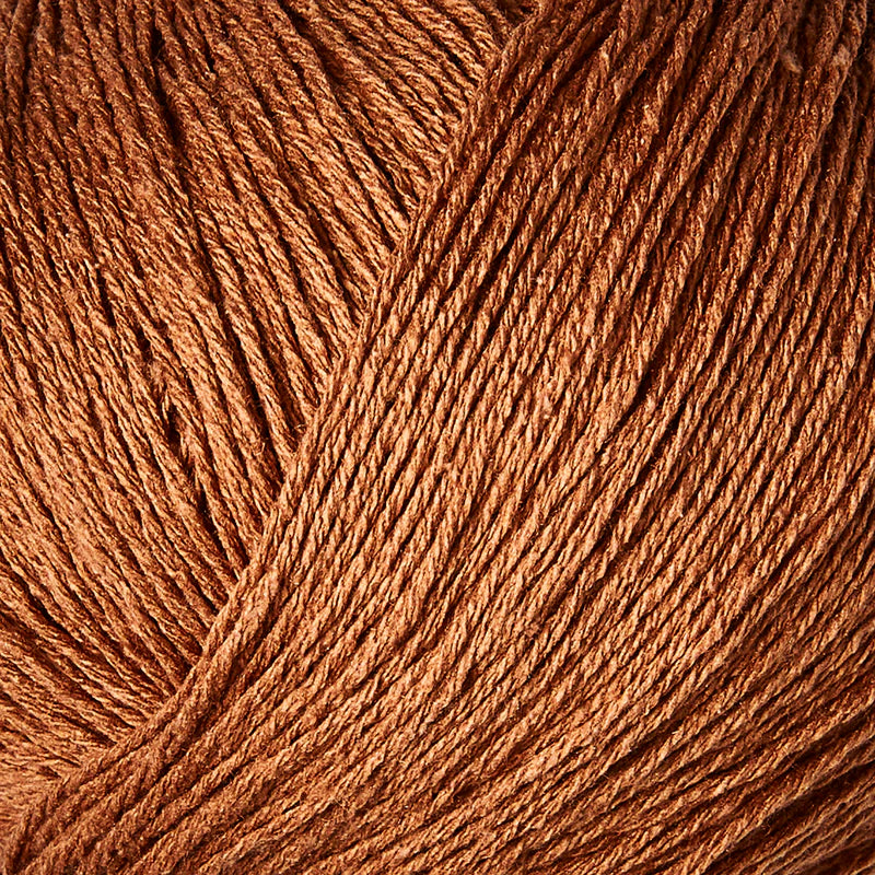 Close-up van koper kleur bourettezijde met een matte uitstraling en een licht onregelmatige, natuurlijke structuur
