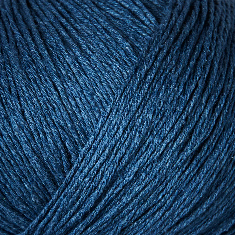 Close-up van blauwe bourettezijde met een matte uitstraling en een licht onregelmatige, natuurlijke structuur