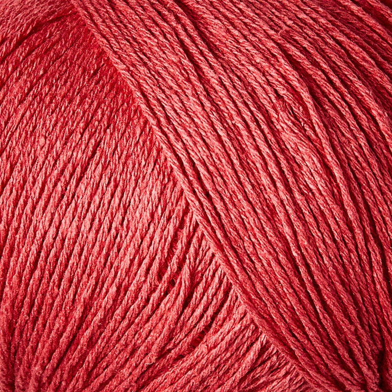 Close-up van watermelon kleurige bourettezijde met een matte uitstraling en een licht onregelmatige, natuurlijke structuur